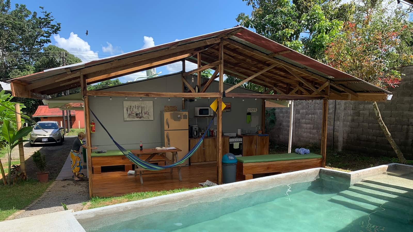 Vista completa del rancho con la cocina, hamaca y piscina en un día soleado — foto real